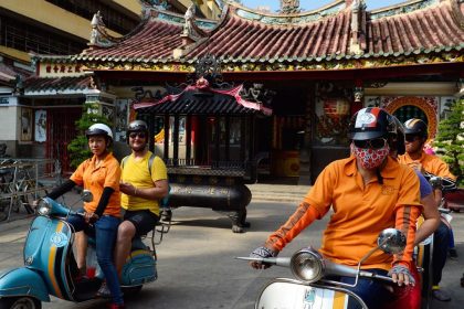 Tài xế chở du khách nước ngoài tham quan chùa cổ ở TP HCM bằng xe Vespa. Ảnh: Mark Eveleigh