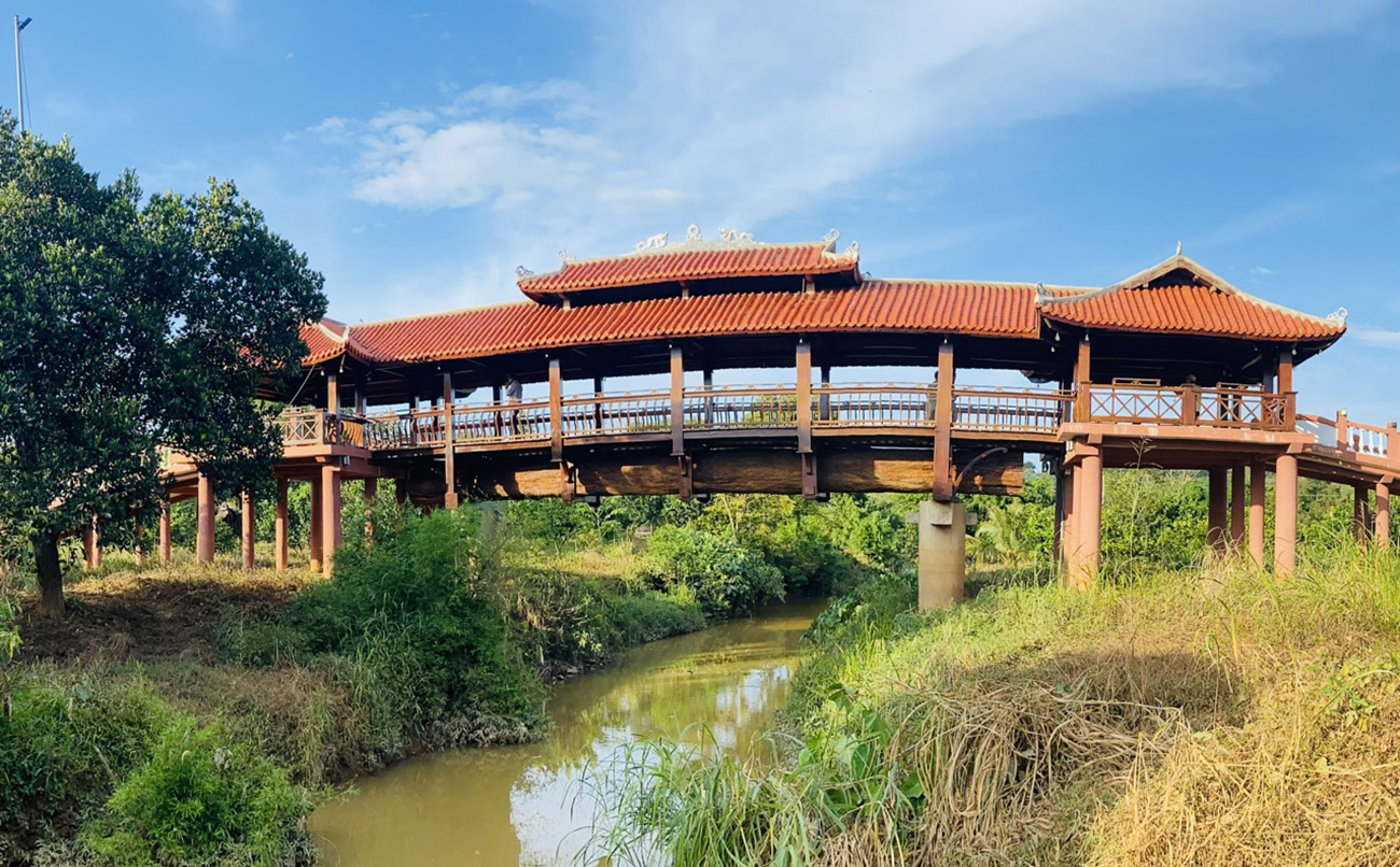 Cầu gỗ lợp ngói có đà cầu là thân gỗ nguyên khối dài nhất châu Á. Ảnh: Nguyễn Nam