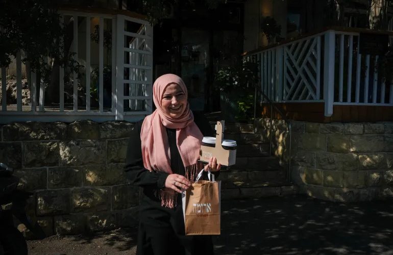 Giảng viên Rania Abu al-Hawa sau khi mua đồ uống tại quán. Ảnh: Al Jazeera