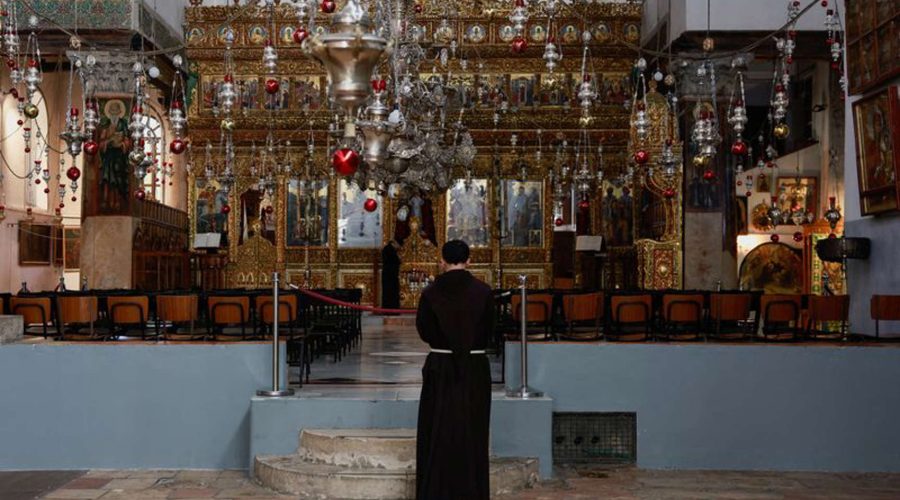 Một tu sĩ đứng bên trong Nhà thờ Giáng sinh vào ngày bắt đầu mùa Giáng sinh, 2/12, tại Bethlehem. Ảnh: Reuters