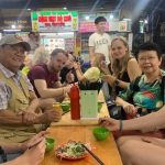 Nhóm du khách nước ngoài thưởng thức nộm bò khô tại phố cổ Hà Nội vào tháng 10. Ảnh: Tripadvisor