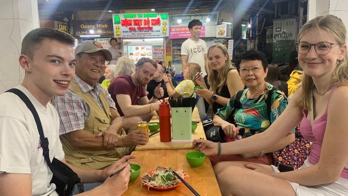 Nhóm du khách nước ngoài thưởng thức nộm bò khô tại phố cổ Hà Nội vào tháng 10. Ảnh: Tripadvisor