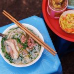 Phở bò Ấu Triệu ngồi trên ghế nhựa ở vỉa hè. Ảnh: Michelin Vietnam